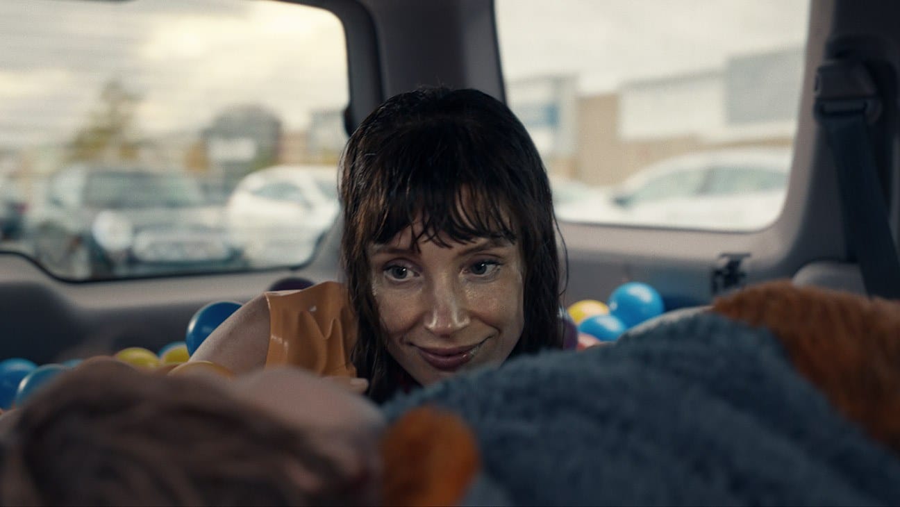 Jessica Chastain as the entity in Other Mommy, smiling in the back of a car
