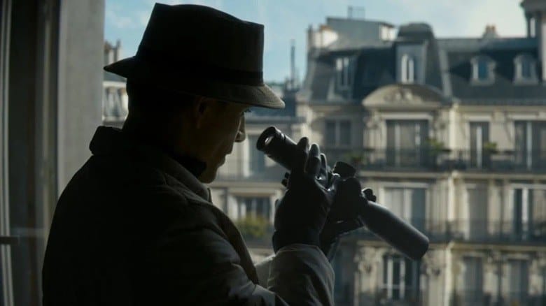 A silhouetted assassin observing a Paris apartment block in David Fincher's The Killer