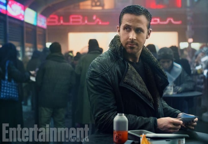 Officer K in a crowded, neon-lit street scene from Blade Runner 2049