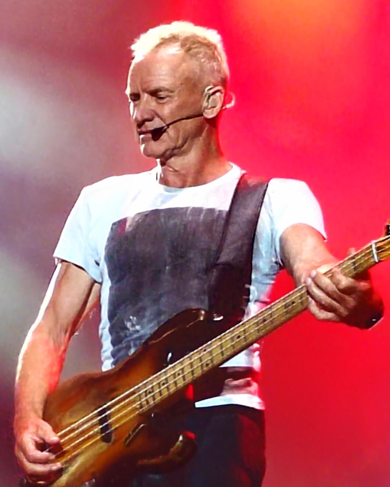 Sting playing bass guitar on stage in 2025