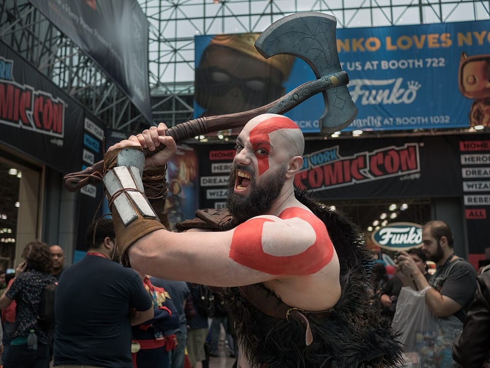 A Kratos cosplayer brandishing an axe on the New York Comic Con show floor at the Javits Center