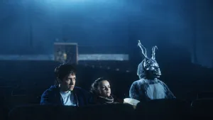 Donnie, Gretchen and Frank the rabbit sitting together in a dark cinema