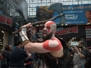 A Kratos cosplayer brandishing an axe on the New York Comic Con show floor at the Javits Center
